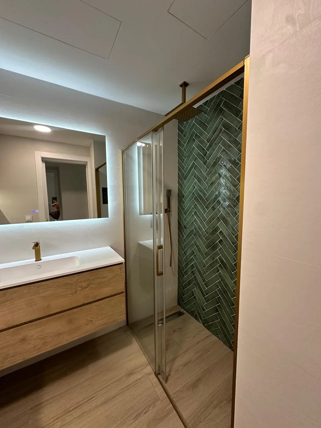 Ducha con mampara y revestimiento verde en espiga