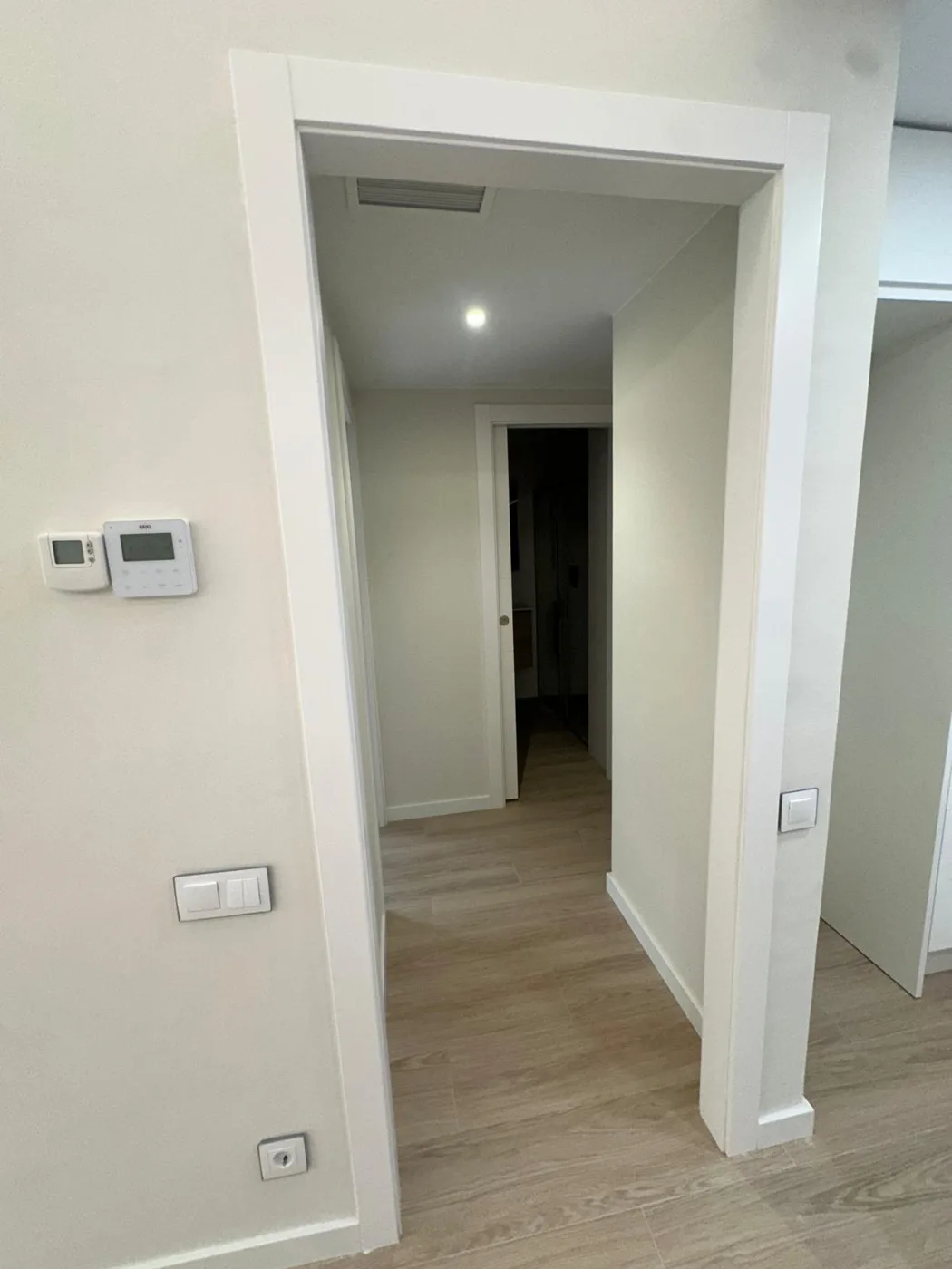 Interior renovado con puertas blancas y pavimento de tono madera
